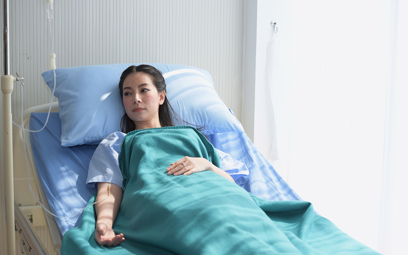 A sick person lying in a hospital bed