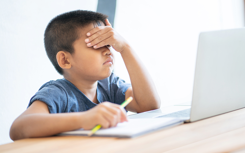 Image of a sad young child looking at a test
