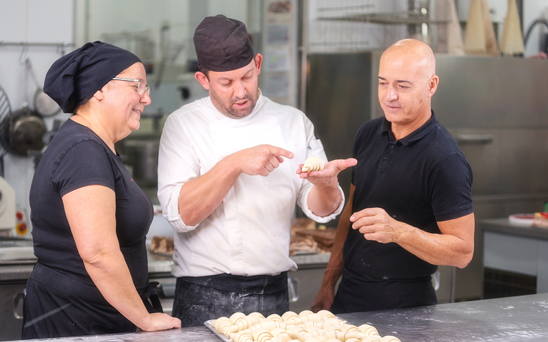 A pastry chef teaching a student