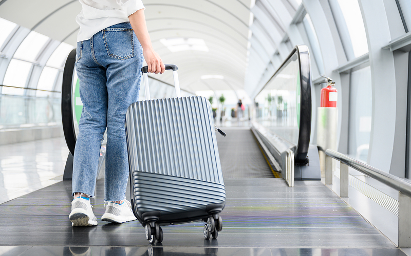A person rolling his suitcase in the airport
