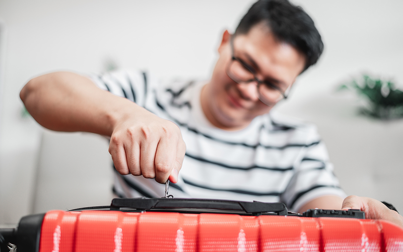 Image of a person fixing a suitcase