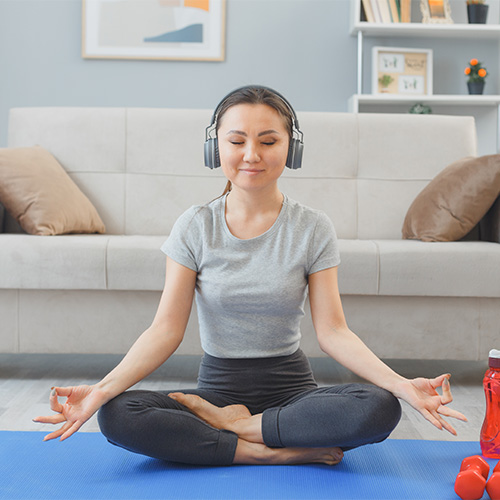Small image of a a person wearing headphones during yoga