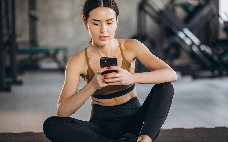 Image of person in the gym checking their phone