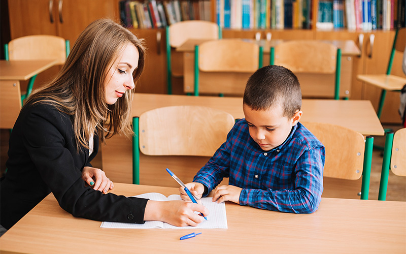 a young student studying well while being guided by a tutor at a tuition class